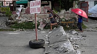 يسير السكان على طريق متضرر بسبب زلزال قوي وقع مؤخرا في مدينة بوجو, مقاطعة سيبو, وسط الفلبين يوم الخميس, أكتوبر. 2, 2025.