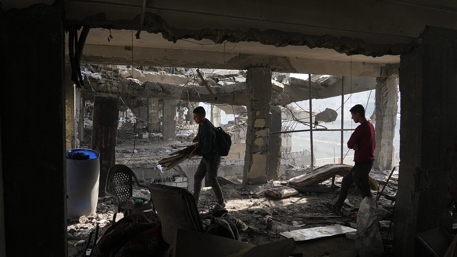 Палестинцы в городе Газа проверяют здание после удара Израиля