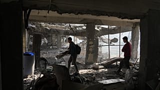 Палестинцы в городе Газа проверяют здание после удара Израиля