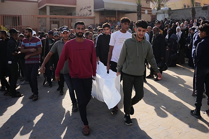 Des personnes en deuil transportent le corps d'une victime d'une frappe de l'armée israélienne, à l'hôpital Nasser de Khan Younès, le jeudi 20 novembre 2025