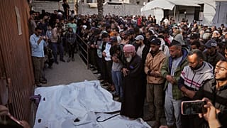 مشيعون يصلون على جثامين الفلسطينيين الذين قتلوا في غارة للجيش الإسرائيلي، خلال جنازتهم في مستشفى ناصر في خان يونس، قطاع غزة الخميس 20 نوفمبر/تشرين الثاني 2025. 