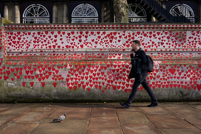 A man walks past the National Covid Memorial Wall on the south bank of the river Thames in London, 14 March, 2024