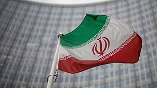 A national flag of Iran waves in front of the building of the International Atomic Energy Agency in Vienna, 17 December, 2021