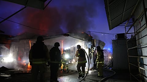 I vigili del fuoco spengono un incendio in un mercato di Zaporizhzhia, distrutto da un attacco aereo russo.