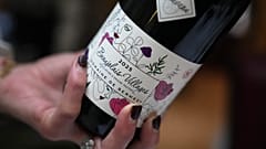 Bir müşteri Beaujolais Nouveau şarabından bir kadeh dolduruyor