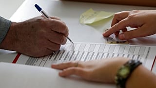 Un hombre firma la lista de nombres de los votantes para obtener su papeleta en un colegio electoral en Bosnia, 2 de octubre de 2016.