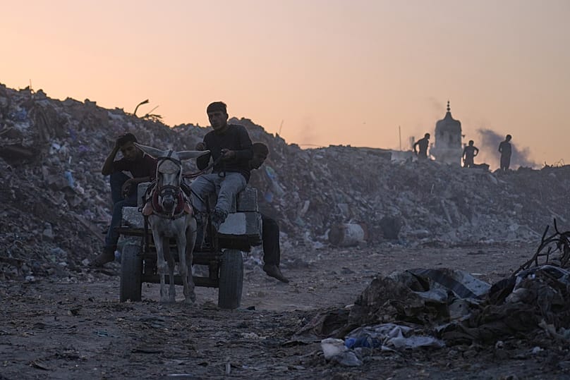 فلسطينيون يبحثون عن الحطب والبلاستيك في مكبّ نفايات بمدينة غزة، السبت، 25 أكتوبر 2025.