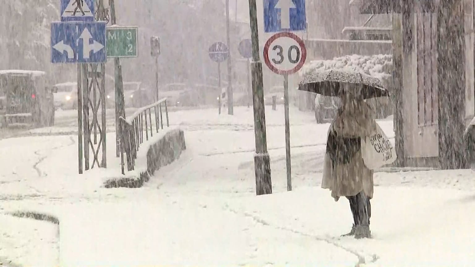 Une femme se protège des fortes chutes de neige sous son parapluie, Pologne, 20 novembre 2025