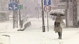 Une femme se protège des fortes chutes de neige sous son parapluie, Pologne, 20 novembre 2025
