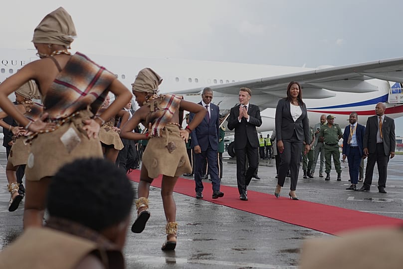 الرئيس الفرنسي إيمانويل ماكرون يصفق للراقصين لدى وصوله إلى مطار أو آر تامبو الدولي في إيكورهوليني، خارج جوهانسبرغ، جنوب أفريقيا، الجمعة 21 نوفمبر/تشرين الثاني 2025.