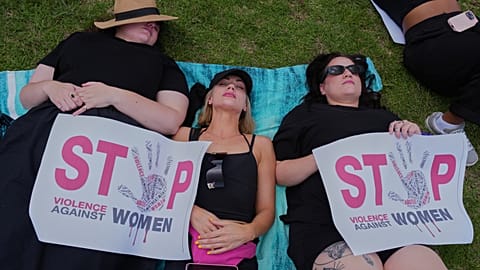 Participants lie on the ground holding signs that read "Stop violence against women" during a gender-based violence protest, Johannesburg, South Africa, Nov. 21, 2025