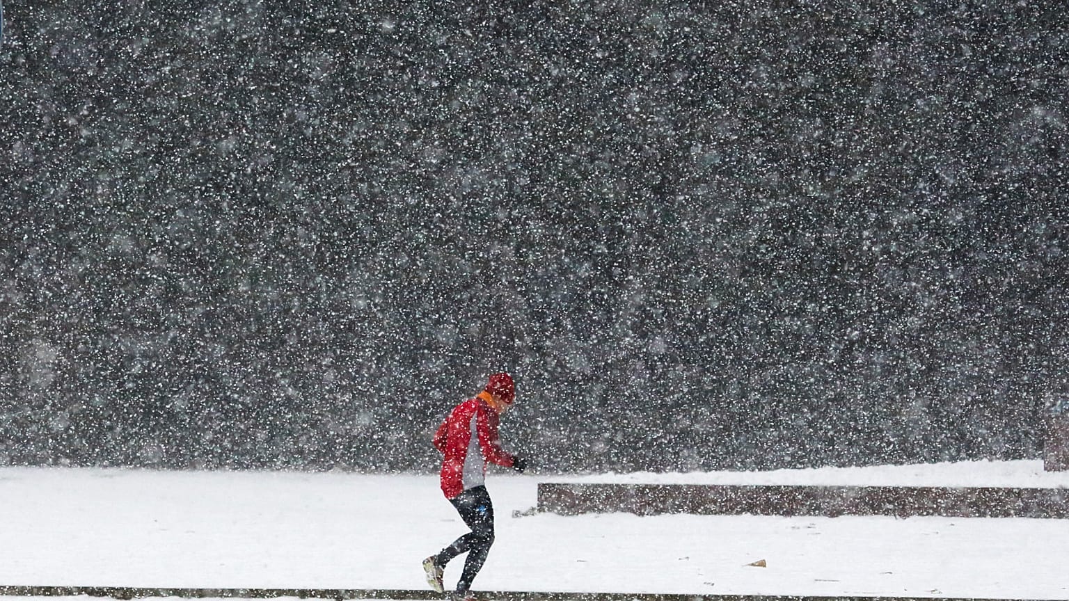 Um homem corre sob forte nevada num dia de tempo invernal em Berlim, quarta-feira, 11 de janeiro de 2017.