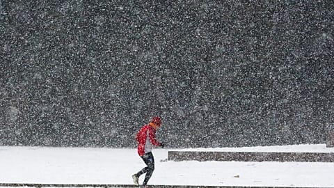 Nevicata a Berlino, mercoledì 11 gennaio 2017: un uomo corre sotto la neve fitta in una giornata di maltempo invernale.