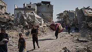 فلسطينيون يسيرون وسط أنقاض جباليا في غزة، يوم الجمعة 21 نوفمبر 2025. (تصوير: جيهاد الشرفي، وكالة أسوشيتد برس)