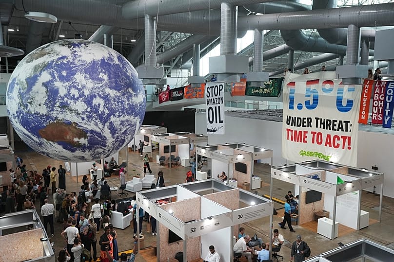 Activists demonstrate with a sign that reads "1.5 degrees Celsius under threat: time to act!" at the COP30 U.N. Climate Summit, Friday, Nov. 21, 2025, in Belem, Brazil. (AP Ph