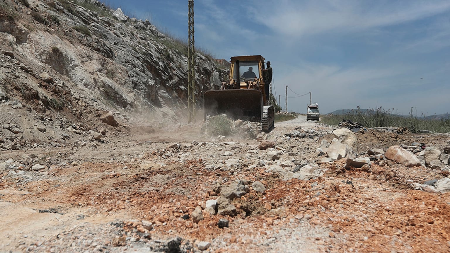 جرافة تغلق حفرة إثر غارات جوية إسرائيلية استهدفت قمم التلال قرب مدينة النبطية، جنوب لبنان، الخميس 8 مايو/أيار 2025.