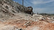 جرافة تغلق حفرة إثر غارات جوية إسرائيلية استهدفت قمم التلال قرب مدينة النبطية، جنوب لبنان، الخميس 8 مايو/أيار 2025.