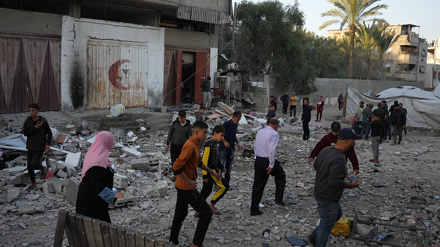 فلسطينيون يتفقدون الأضرار التي لحقت بمنزل استهدفته غارة إسرائيلية في دير البلح، وسط قطاع غزة، يوم السبت 22 نوفمبر 2025. (تصوير: عبد الكريم حنا/أسوشيتد برس)