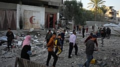 فلسطينيون يتفقدون الأضرار التي لحقت بمنزل استهدفته غارة إسرائيلية في دير البلح، وسط قطاع غزة، يوم السبت 22 نوفمبر 2025. (تصوير: عبد الكريم حنا/أسوشيتد برس)