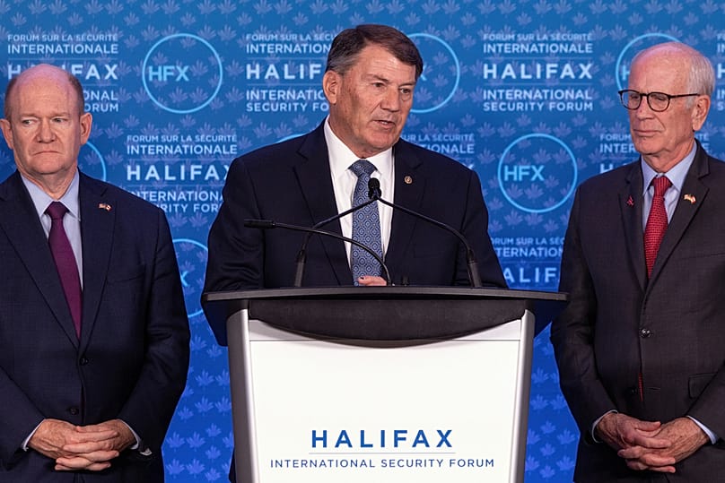 Senator Mike Rounds, R-S.D., przemawia, gdy senatorowie Chris Coons, Del., po lewej, i Peter Welch, D-Vt., po prawej, przyglądają się podczas konferencji prasowej w Halifax International.