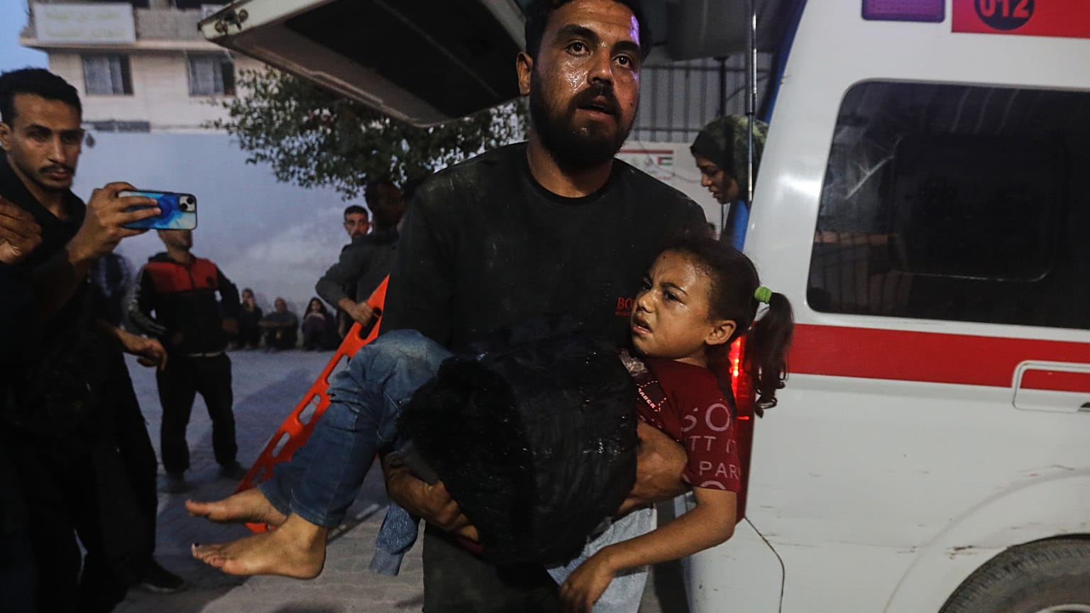 رجل فلسطيني يحمل فتاة مصابة إلى مستشفى الشفاء في أعقاب غارات إسرائيلية على قطاع غزة، السبت 22 نوفمبر/تشرين الثاني 2025