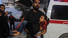رجل فلسطيني يحمل فتاة مصابة إلى مستشفى الشفاء في أعقاب غارات إسرائيلية على قطاع غزة، السبت 22 نوفمبر/تشرين الثاني 2025