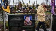 Vira Katanenko, 66, cries while visiting a grave of her son Andrii Katanenko, a Ukrainian serviceman of 59th brigade at the cemetery in Bucha, Ukraine, Nov. 23, 2025.
