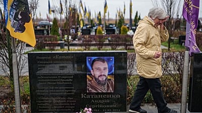Vira Katanenko, 66 anni, piange mentre visita la tomba del figlio Andrii Katanenko, militare ucraino della 59ª brigata, nel cimitero di Bucha, Ucraina, 23 novembre 2025.