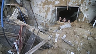 Gazze Şeridi'nin Refah bölgesinde çocuklar yıkılan binalara bakıyor, 14 Ekim 2023.