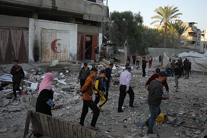 الفلسطينيون يتفقدون أضرار منزل استُهدف بضربة إسرائيلية في دير البلح وسط قطاع غزة، السبت، 22 نوفمبر 2025.