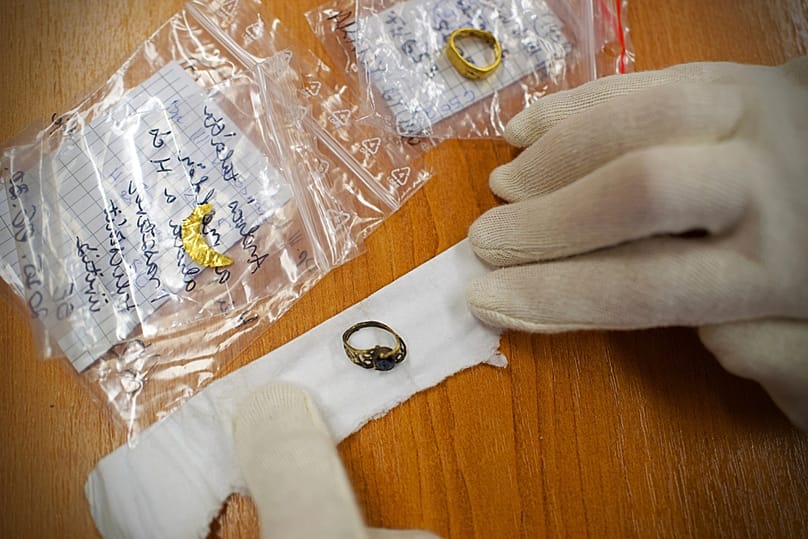 An archaeologist shows golden jewelry found at an archeological site where an intact Roman sarcophagus was unearthed, Wednesday, Nov. 19, 2025 in Budapest, Hungary.
