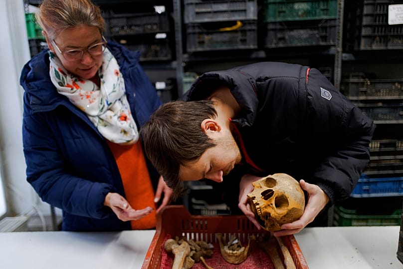Hungarian archaeologists Gabriella Fenyes, left, and Gergely Kostyal inspect the skull of a Roman-era woman after her remains were found, Wednesday, Nov. 19, 2025 in Budapest,