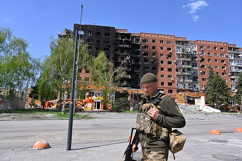 FILE: A Ukrainian soldier walks past damaged buildings in central Pokrovsk, in the Donetsk region of Ukraine, 23 April 2025
