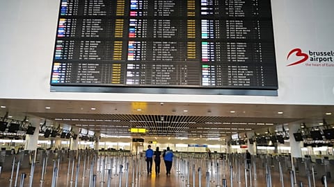 Employees walk through an empty terminal with a departure board of cancelled flights at Brussels International Airport during strikes in October. 
