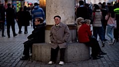 Madrid, Spanien: Menschen sitzen auf einer öffentlichen Sitzbank an der Puerta del Sol. 13. März 2014.