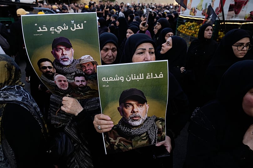 مناصرون لحزب الله يرفعون صور هيثم الطبطبائي ومقاتلين آخرين قُتلوا في الغارة الإسرائيلية يوم الأحد، خلال تشييعهم في الضاحية الجنوبية لبيروت، في 24 نوفمبر 2025.