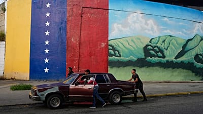 FILE: Persone spingono un'auto in panne a Caracas, 20 novembre 2025