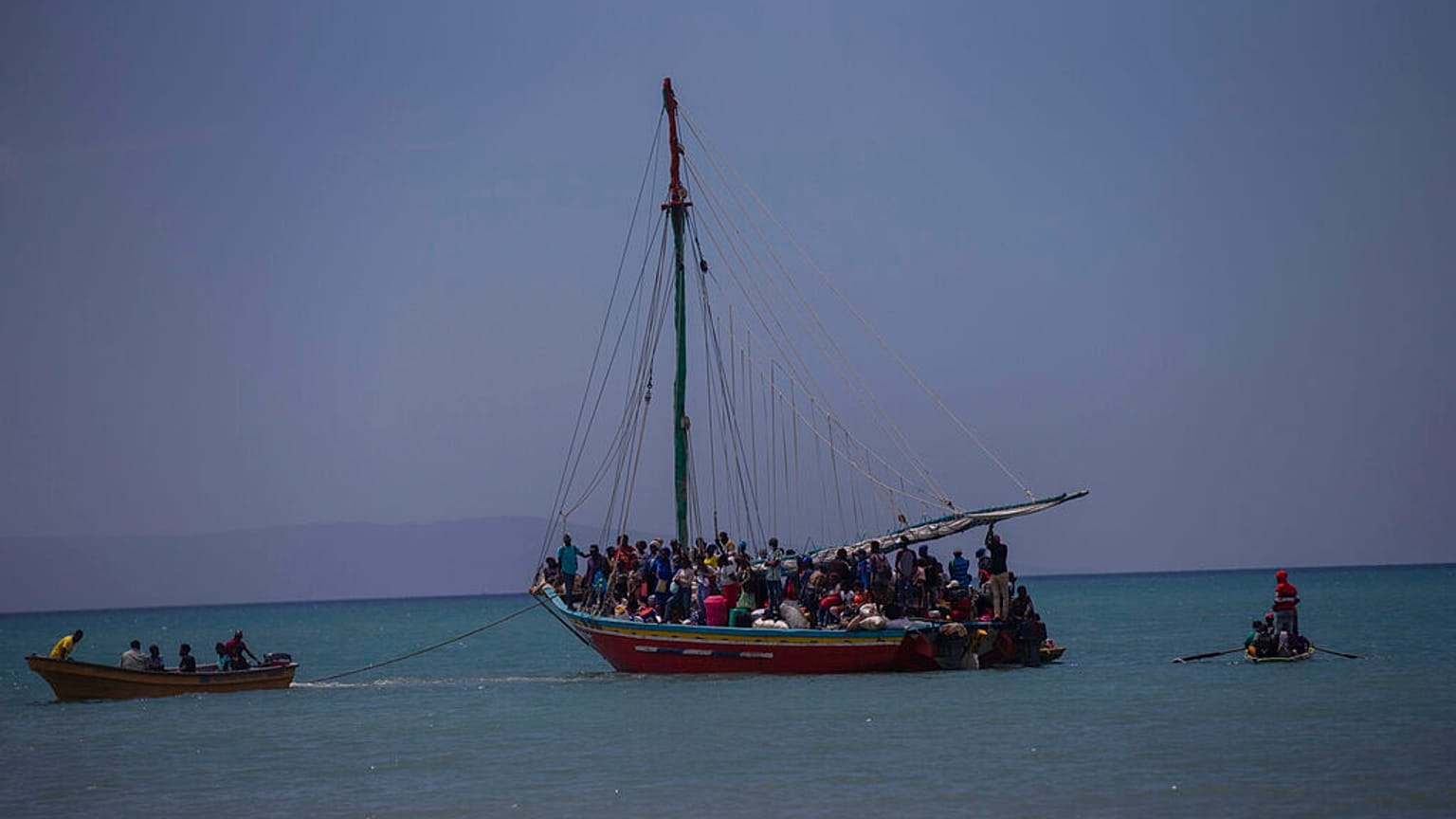 FILE: Passeggeri su skiff provenienti dall'isola di Gonave aspettano che piccole barche di legno li trasportino a riva a Léogane, Haiti, 21 luglio 2022