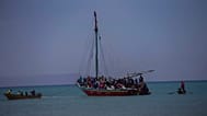FILE: Passeggeri su skiff provenienti dall'isola di Gonave aspettano che piccole barche di legno li trasportino a riva a Léogane, Haiti, 21 luglio 2022