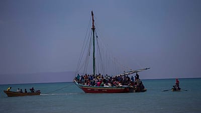 FILE: Passeggeri su skiff provenienti dall'isola di Gonave aspettano che piccole barche di legno li trasportino a riva a Léogane, Haiti, 21 luglio 2022