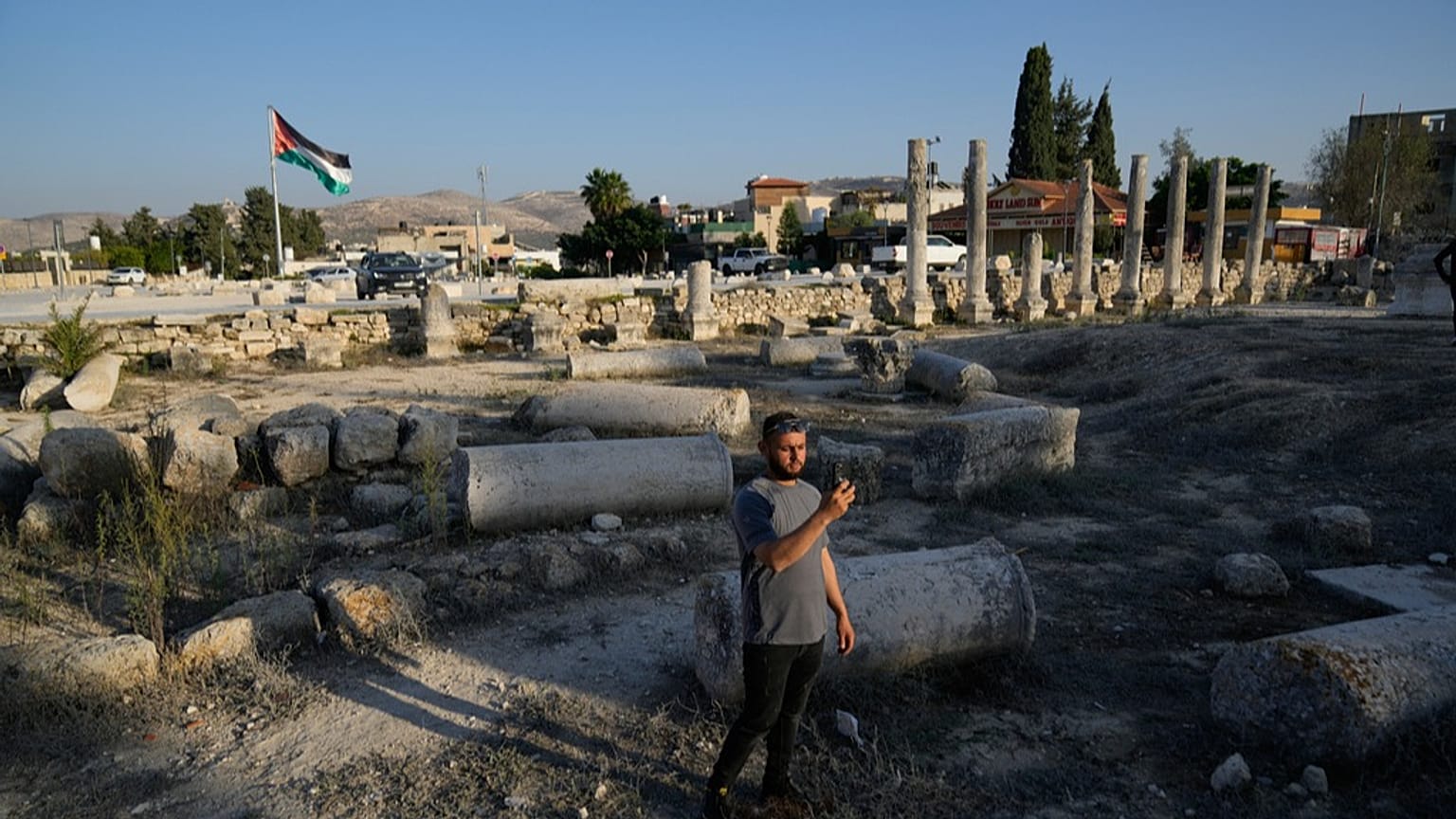 فلسطيني يلتقط صورة في الموقع الروماني التاريخي في بلدة سبسطية في الضفة الغربية.