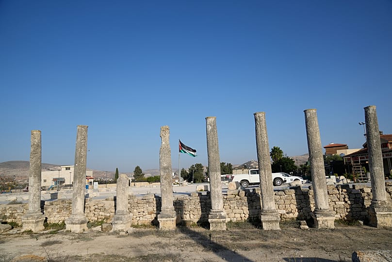 علمٌ فلسطيني يرفرف فوق الموقع الروماني التاريخي في بلدة سبسطية في الضفة الغربية، في 20 نوفمبر 2025.