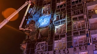 Emergency services personnel work to extinguish a fire following a Russian attack in Kyiv, Ukraine, Tuesday, Nov. 25, 2025