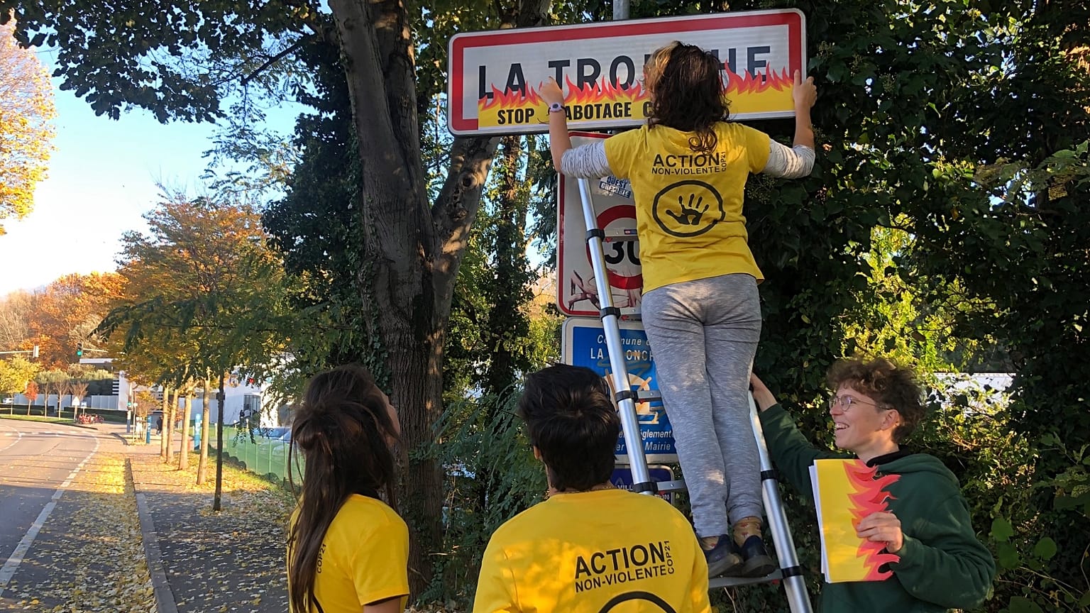 Activists glue fake flames onto road signs in France.