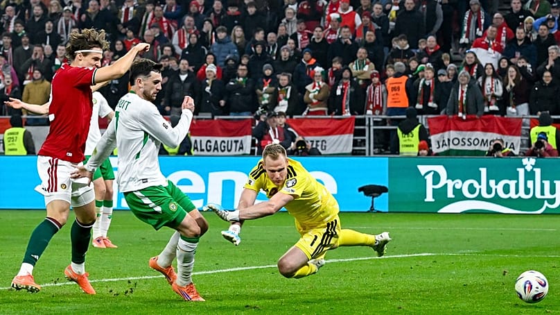 Az ír Troy Parrott (fehér mezben) pöckölése a magyar kapuba tart a magyar-ír (2-3) labdarúgó vb-selejtező 96. percében a Puskás Arénában 2025. november 16-án