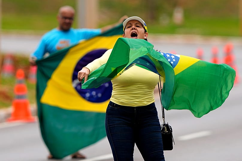 أنصار الرئيس السابق جايير بولسونارو يحتجون خارج مقر الشرطة الفيدرالية، حيث يُحتجز، في برازيليا، البرازيل، الأحد 23 نوفمبر/تشرين الثاني 2025.