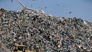 Earthmovers push mountains of garbage as seagulls fly over the country's largest landfill at Fyli on the outskirts of Athens. Feb. 2, 2018  