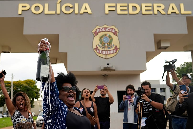 Detractors of former President Jair Bolsonaro celebrate his sentence for leading a coup attempt where he is under arrest in Brasilia, Brazil, Tuesday, Nov. 25, 2025