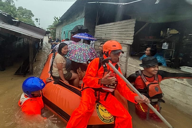 Rescuers on a rubber boat evacuate residents from their flooded home in North Sumatra province, Indonesia Tuesday, Nov. 25, 2025