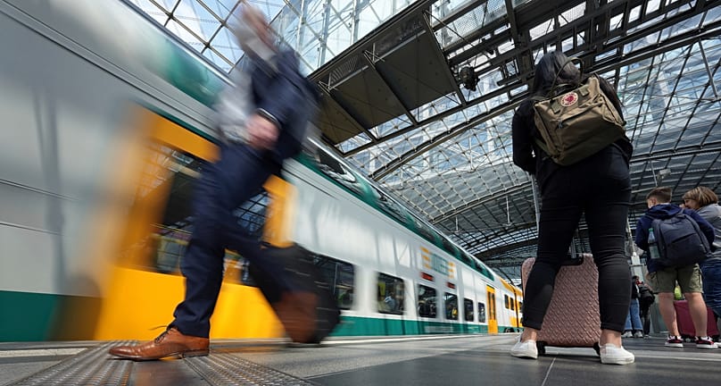 FILE: Travellers wait on a platform as a train arrives at the main train station in Berlin, 1 June 2022